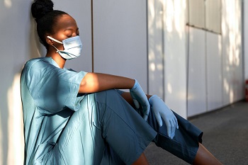 Tired nurse sits on the floor in a hospital.